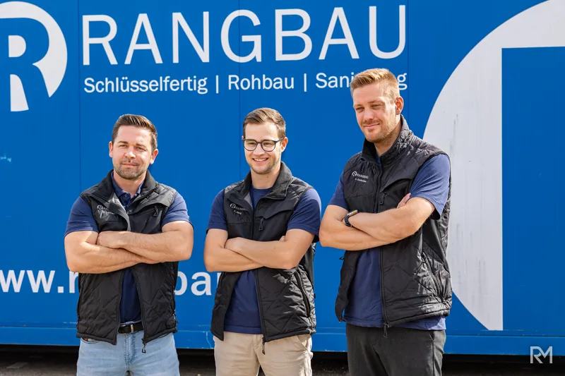 Das Team von Rang Bau vor dem Firmenbanner